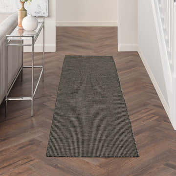 Entryway featuring Nourison Positano Charcoal runner rug, wood floors, and a modern console table.