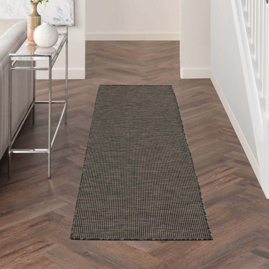 Entryway featuring Nourison Positano Charcoal runner rug, wood floors, and a modern console table.