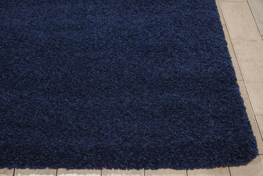 Close-up of the plush texture and rich navy color of the Nourison Malibu Shag rug. Rectangle shag rug on light wood floor.