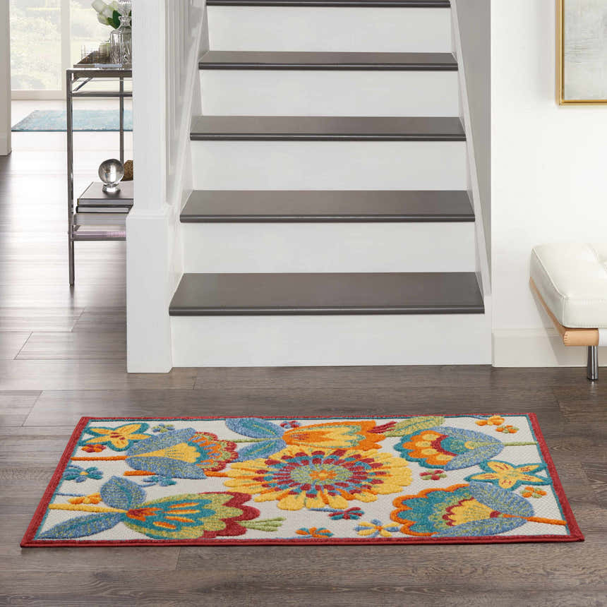 Entryway with stairs and a Nourison Aloha Multicolor rug with floral pattern on dark wood floor.