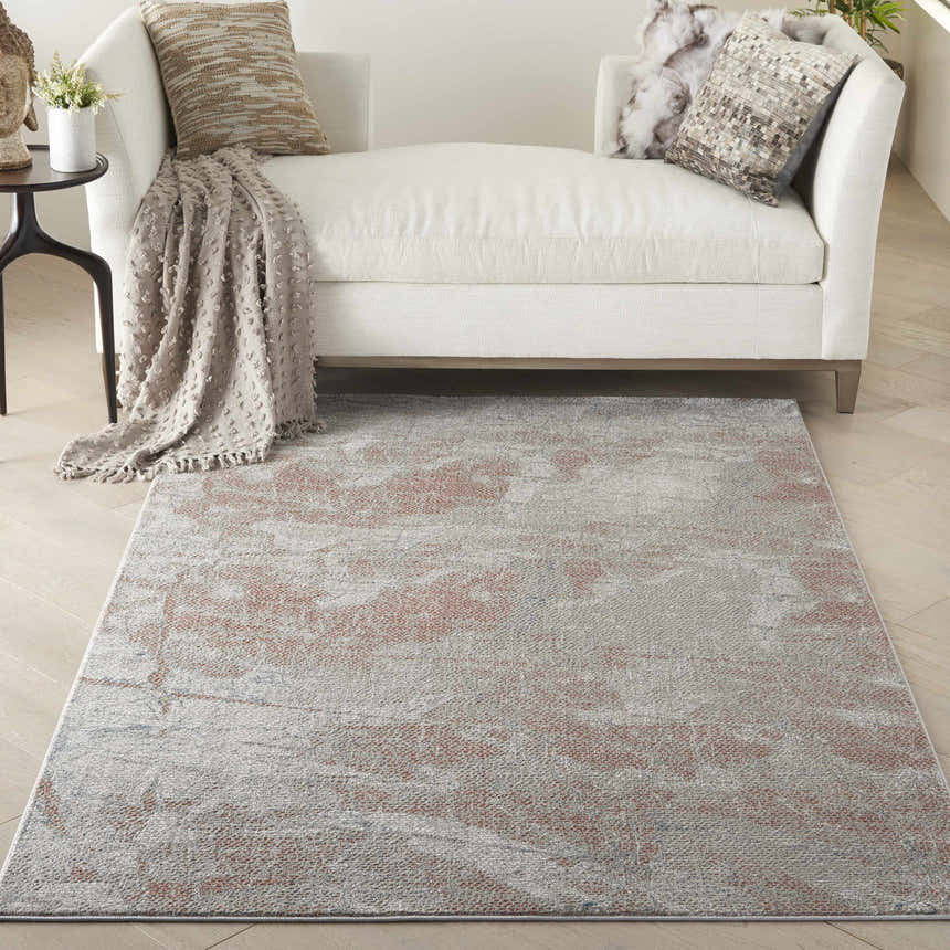 Living room scene with a Nourison Rustic Textures Light Grey Rust rug, white sofa, wood floors, and neutral decor.