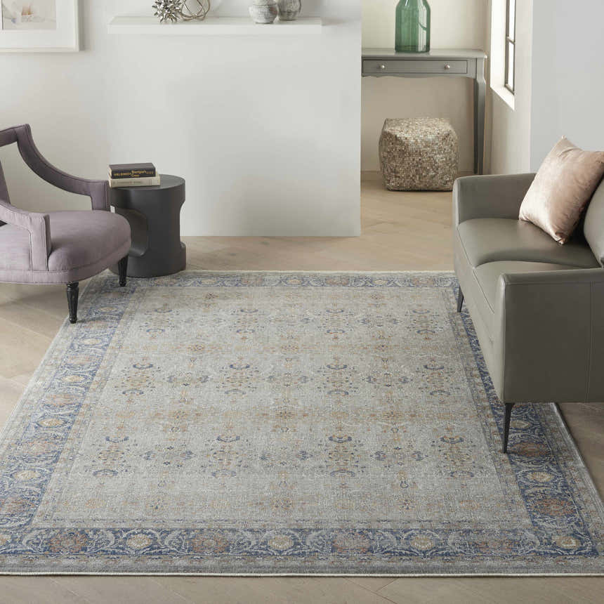 Living room scene with a grey sofa and the Nourison Starry Nights Grey Vintage Area Rug adding a touch of vintage charm.