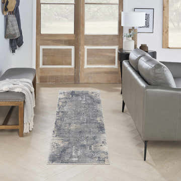 Living room scene with grey sofa and Nourison Rustic Textures Grey Beige modern rug on light wood floors.