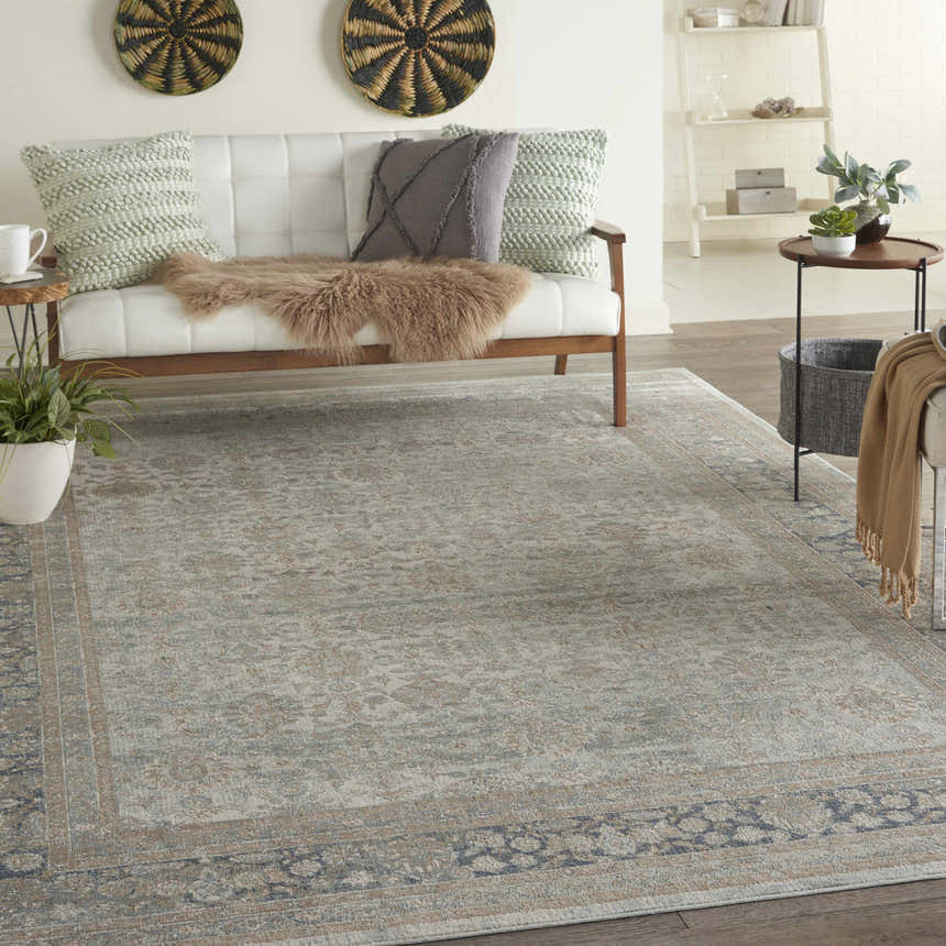 Living room scene with a Cloud Nourison Malta vintage rug, white sofa, and wood accents.