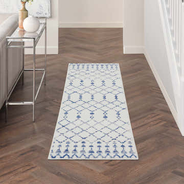 Hallway with Nourison Whimsicle Ivory Bohemian runner rug, chestnut wood floors, and chrome console table.