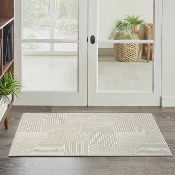 Entryway with Nourison Natural Texture Beige Ivory rug, wood floors, white doors, and garden view.