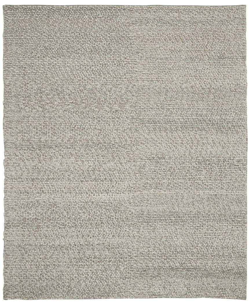 Close-up of Calvin Klein Riverstone rug. Handmade wool rug in grey and ivory with a textured, pebble-like design.