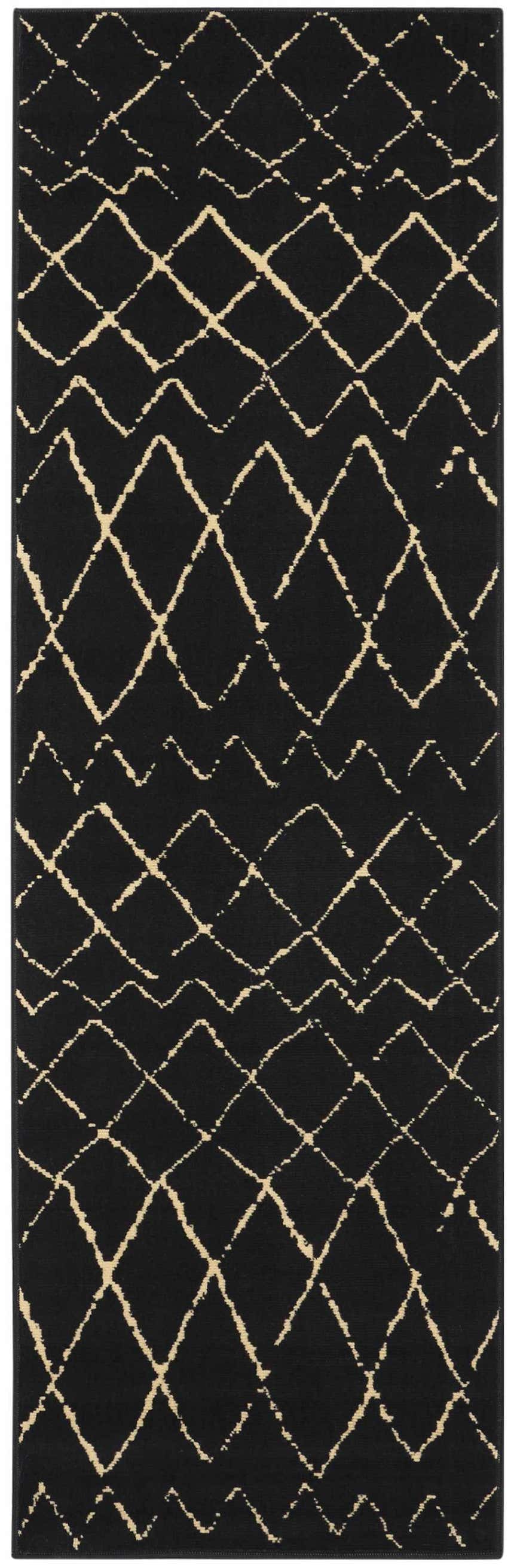 Close-up of the Nourison Grafix Black Bohemian Indoor Area Rug. Features a geometric diamond pattern in beige against a black background.