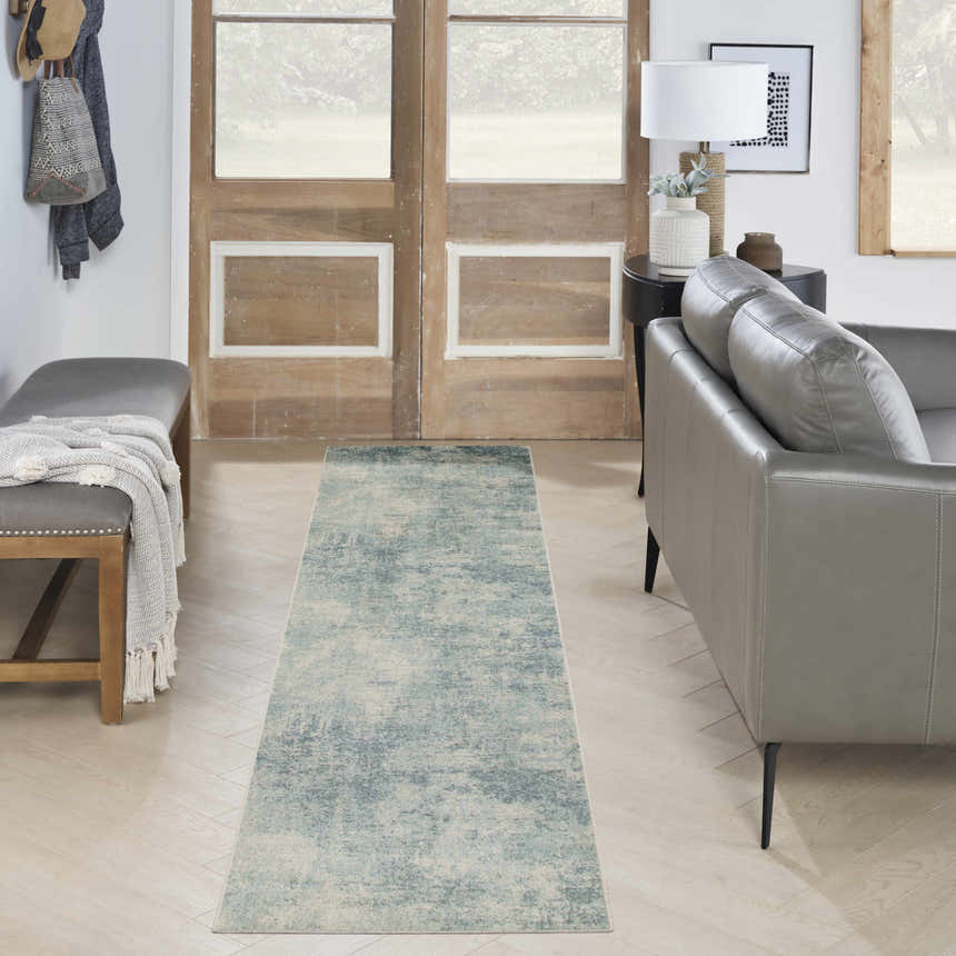 Entryway with a gray leather sofa and Nourison Astra Blue Ivory Runner Rug.
