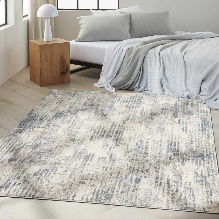Modern bedroom scene with Calvin Klein CK022 Infinity Ivory Grey Blue rug, wood floors, and gray bedding.