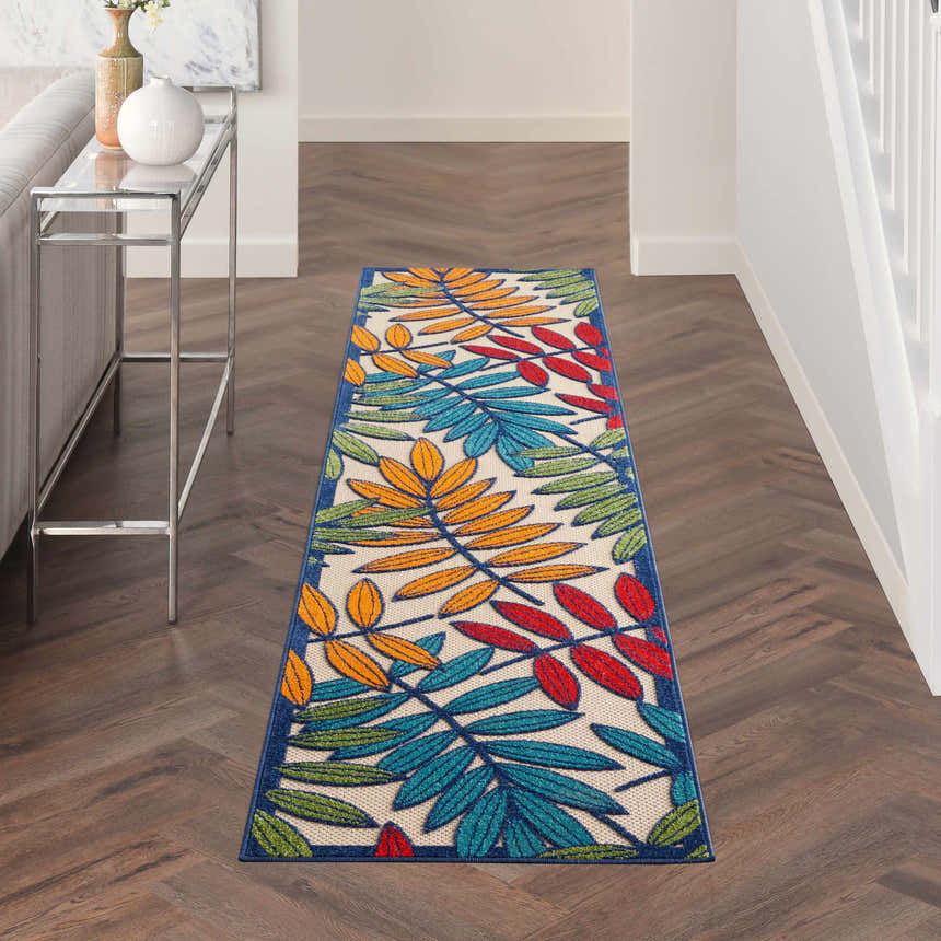 Hallway with Nourison Aloha Multicolor Tropical Area Rug runner, wood floors, and modern console table.