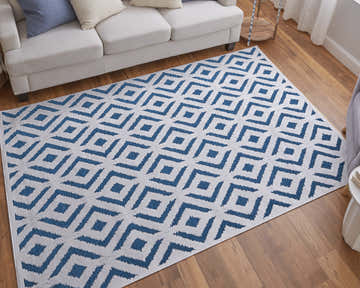 Living room scene with a Feizy Saphir Mira rug in blue and white geometric pattern under a white sofa. Roomscene-Rectangle