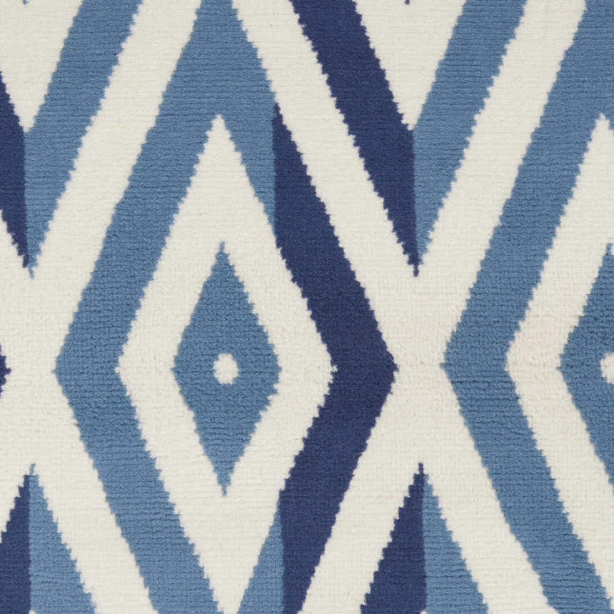 Close-up of Nourison Grafix White Blue rug. Geometric diamond pattern in shades of blue on a white background.
