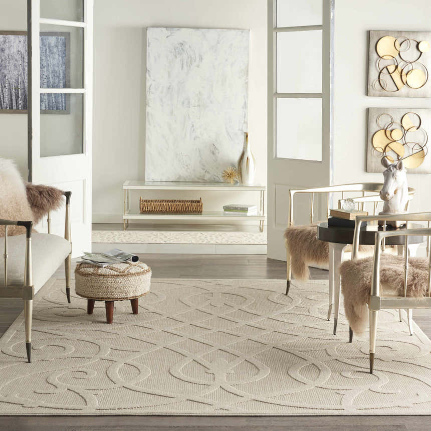 Living room scene with cream furniture and a Nourison Cozumel Cream Farmhouse Area Rug, featuring a geometric design.