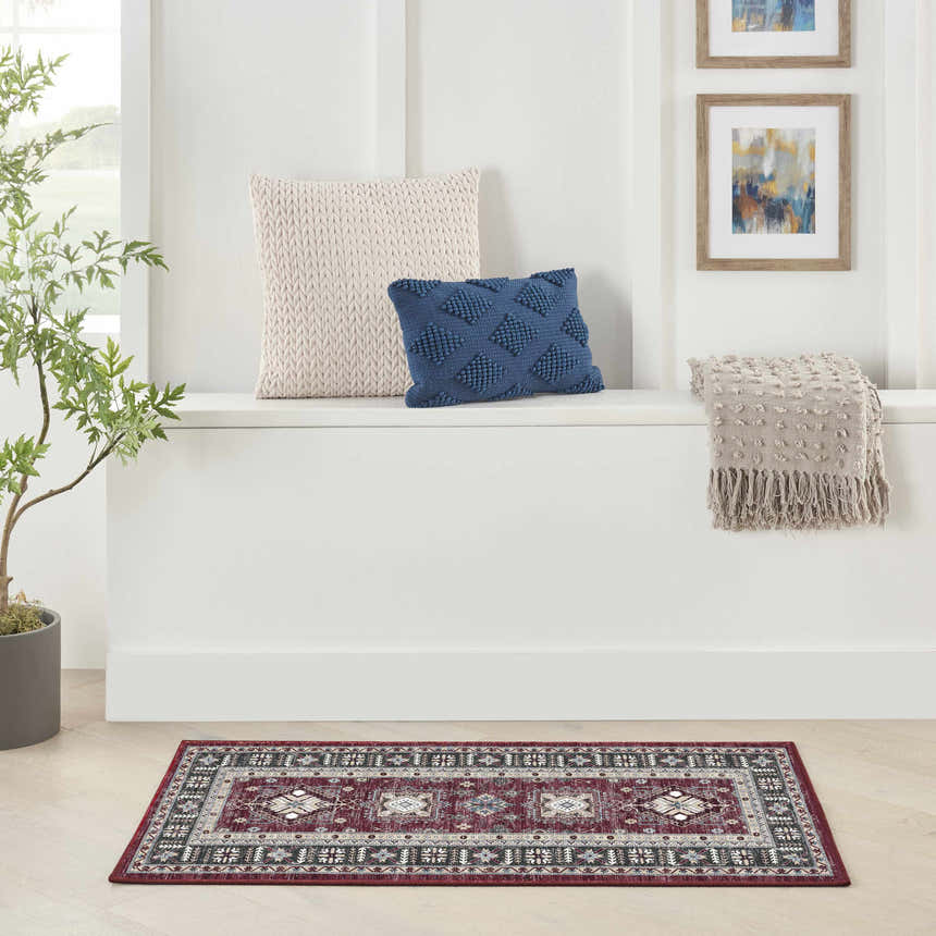Bright entryway with a Nourison Fulton Red Vintage rug, white bench, pillows, and framed art.