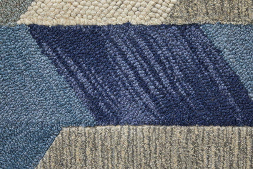Close-up of the Feizy Arazad rug. Geometric design in shades of blue, ivory, and gray. Hand-tufted texture detail. Texture