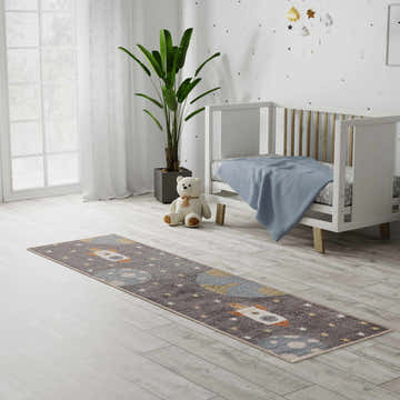 Nursery scene with a Nourison Astra Sky Blue Kids rug, crib, teddy bear, and plant. Soft, playful decor.