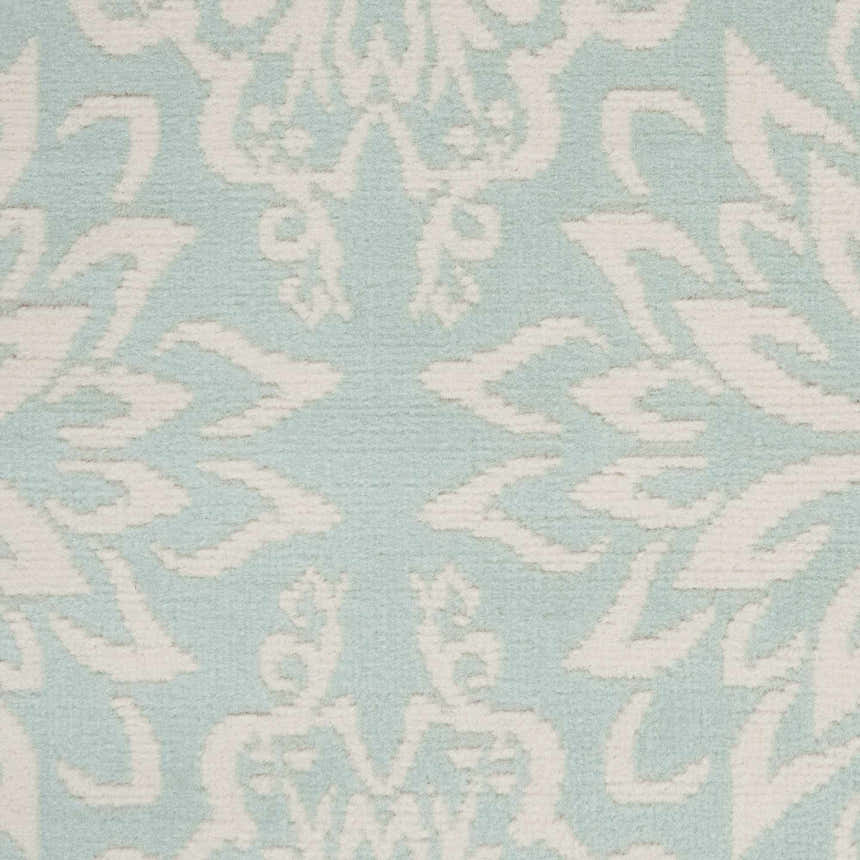 Close-up of the Nourison Jubilant Ivory Green rug showing a detailed damask pattern in ivory against a soft green background.
