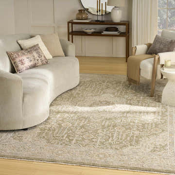 Living room with a curved sofa and a Nourison Retreat Green Vintage Indoor Area Rug.