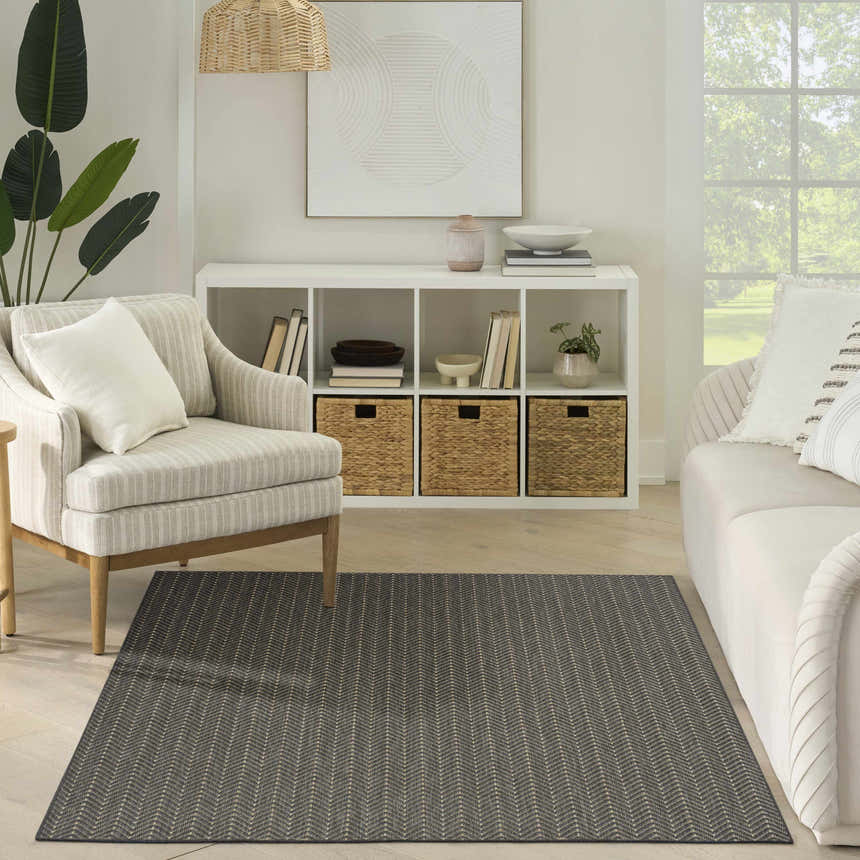 Living room with neutral furniture and Nourison Horizon Charcoal rug featuring a modern chevron pattern.