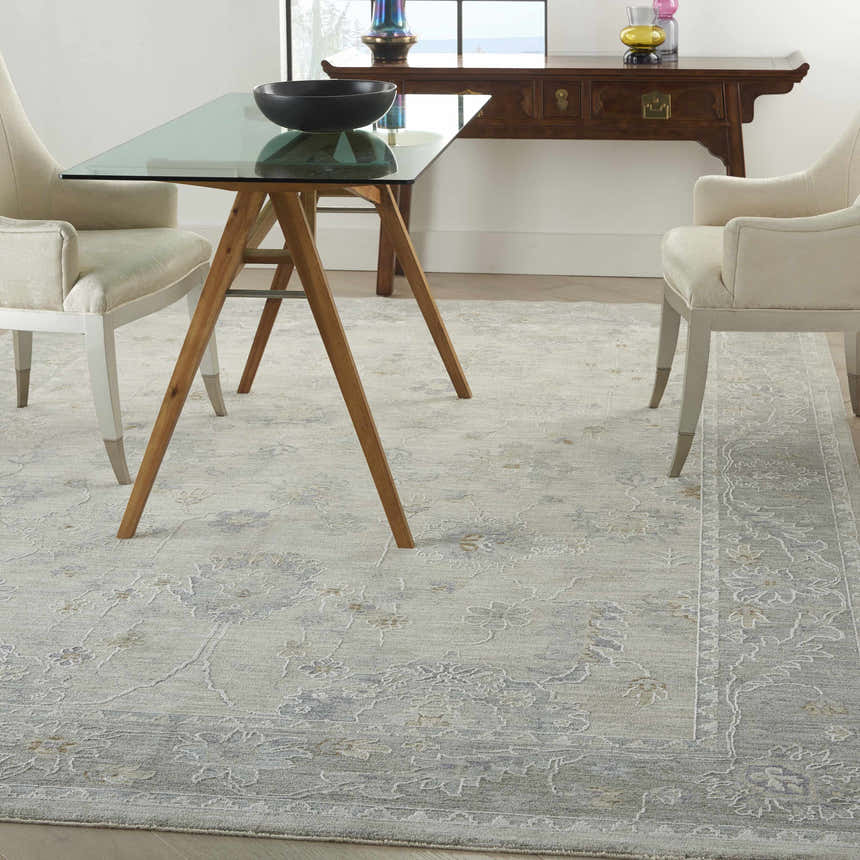 Dining room with a glass table and the light gray vintage Nourison Infinite area rug.