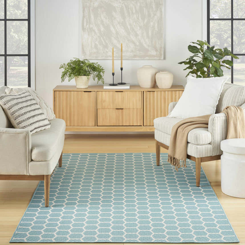 Living room with a Nourison Twist Reversible Aqua rug, light wood furniture, and natural light from a large window.