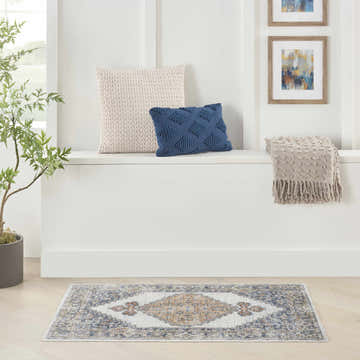 Bright hallway with Nourison Astra Grey Gold Vintage rug, pillows, throw, plant, and framed art.