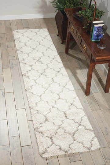 Entryway with Nourison Amore Cream Shag runner rug, wood floors, and console table with decor.