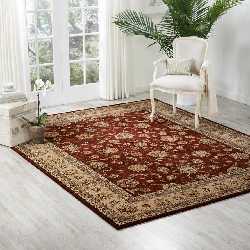 Bright living room with a Nourison 2000 Brick Persian rug, white chair, and light wood floors.