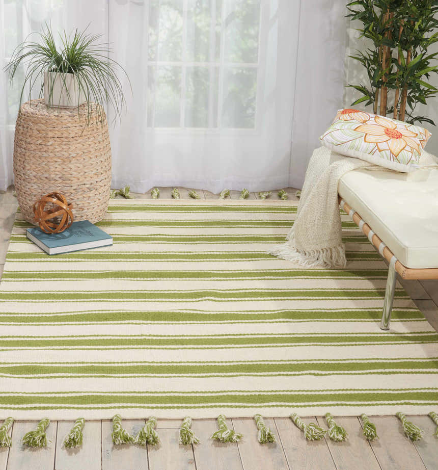 Sunlit room with ivory bench and Nourison Rio Vista rug in green stripes and tassels.