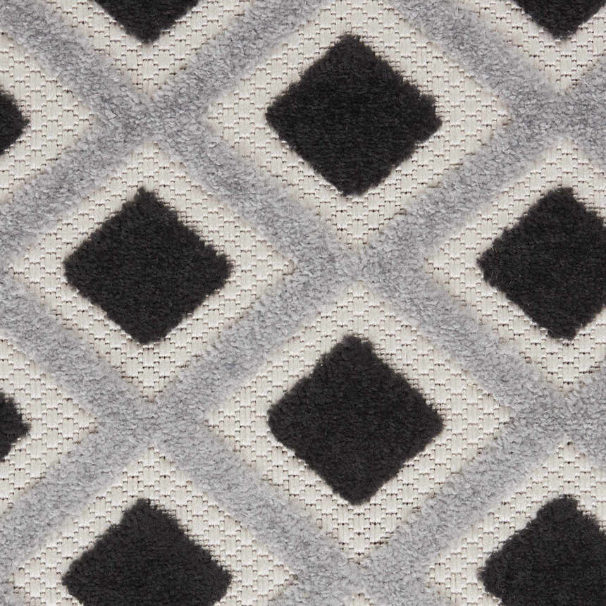 Close-up of the Nourison Aloha Black White Modern Area Rug featuring a geometric diamond pattern and textured weave.