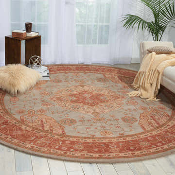 Living room scene with a round Nourison Heritage Hall Aqua Rug, sofa, and side table.