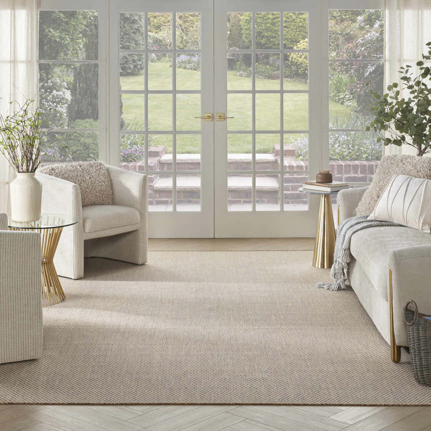 Light-filled living room with a Nourison Courtyard Jute Ivory Modern Area Rug, neutral furniture, and garden view.