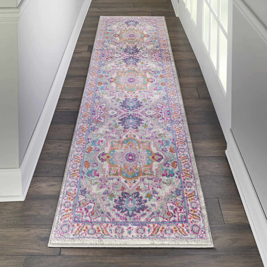 Hallway with Nourison Passion Light Grey Pink Bohemian runner rug on dark wood floor. White walls and door.