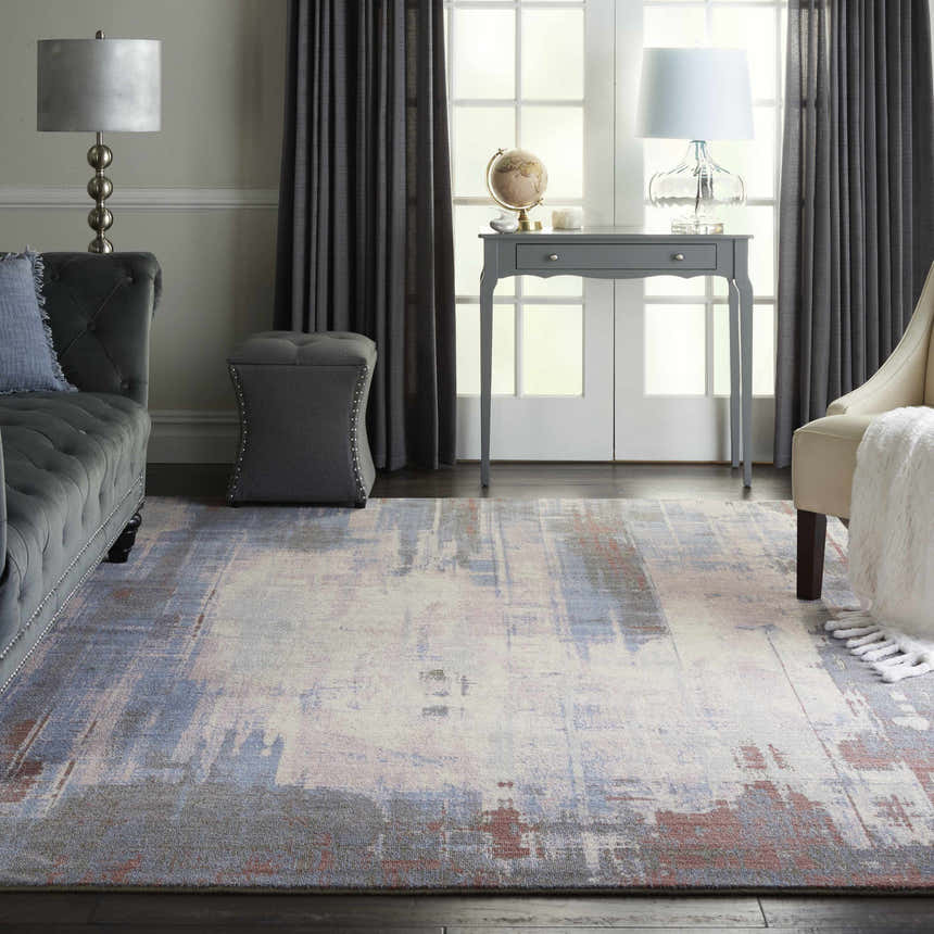 Living room scene with a Nourison Artworks Multicolor rug, gray sofa, and neutral armchair. Modern, stylish decor.