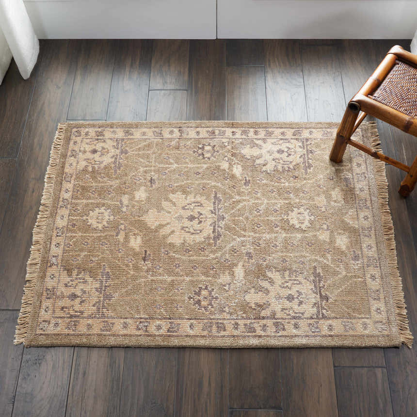 Close-up of the Nourison Aldora Opal Grey Vintage Area Rug on dark wood floors with a light floral pattern and fringe.