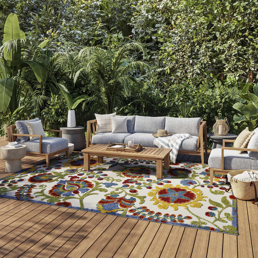 Outdoor patio scene with gray furniture and Nourison Aloha Ivory Multicolor Farmhouse Area Rug with floral chestnut pattern.