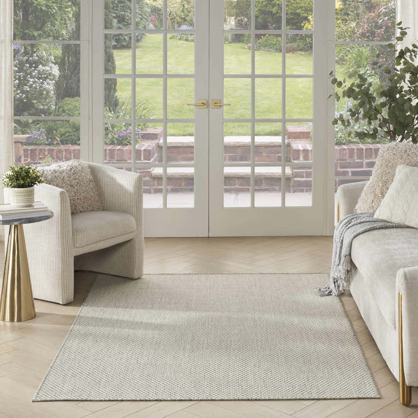 Living room scene with ivory sofa and Nourison Courtyard Ivory Silver Modern Area Rug, light and airy.
