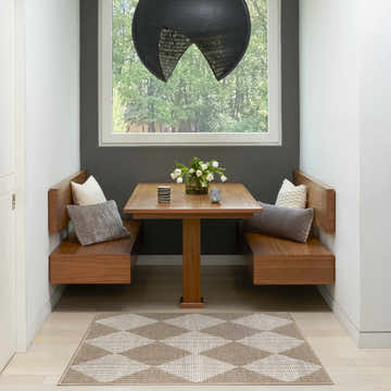 Breakfast nook with Nourison Modern Jute Natural Ivory rug, wood table, built-in benches, gray accent wall, and modern pendant light.