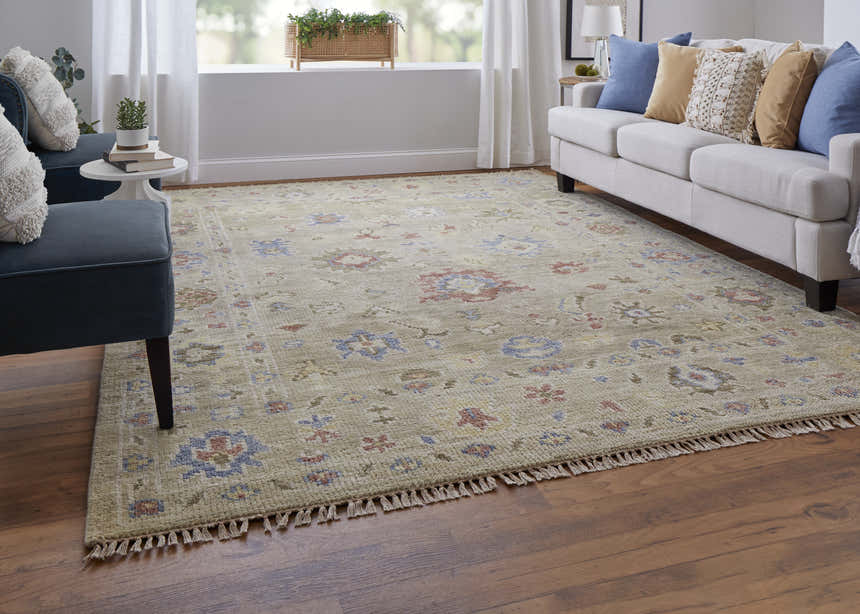 Living room scene with Feizy Fillmore rug in tan, blue, and red floral pattern. Sofa, chair, and wood floors. Roomscene-Rectangle