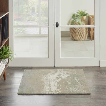 Entryway scene with Nourison Twilight Ivory Green rug on wood floor, white double doors to patio.