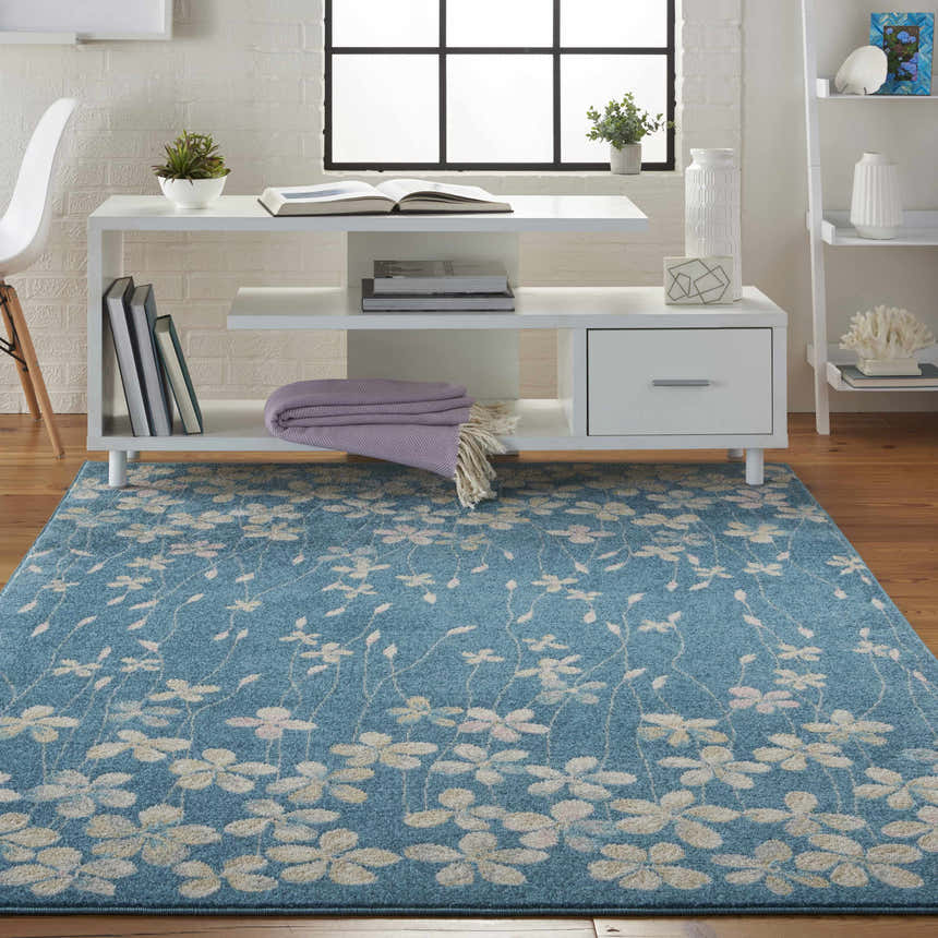Bright living room with white furniture and the Nourison Tranquil Turquoise area rug with a floral pattern.