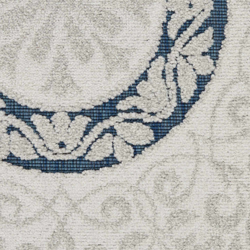 Close-up of Nourison Key Largo Blue rug showing light blue floral pattern on a textured, machine-made contemporary rug.