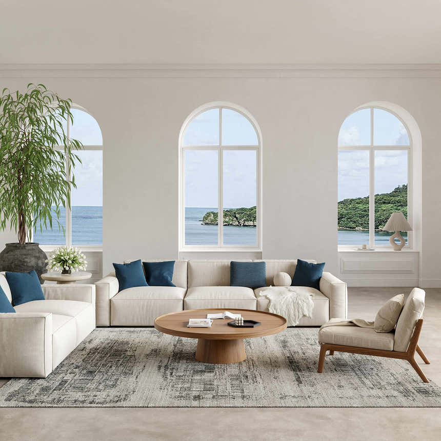 Coastal living room with ivory sofas, blue pillows, and Nourison Harmony Ivory Charcoal rug.