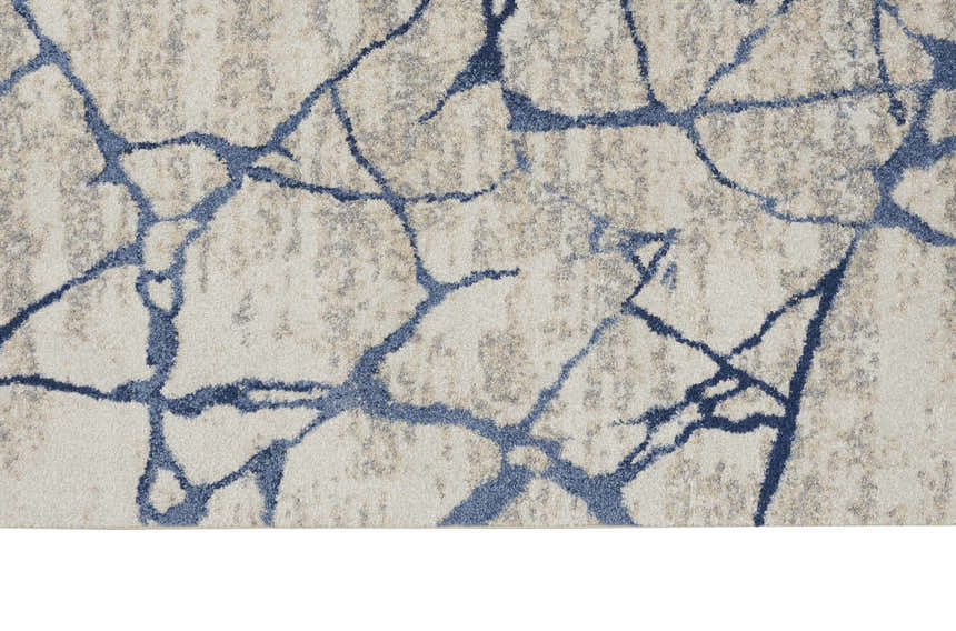 Close-up of Calvin Klein River Flow Ivory Blue rug. Modern design with abstract blue pattern on a neutral background.
