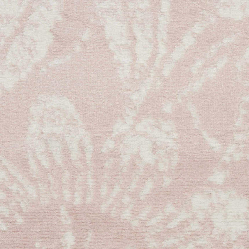 Close up of the Nourison Whimsicle Pink Farmhouse rug, showing a soft pink and white floral pattern and textured weave.