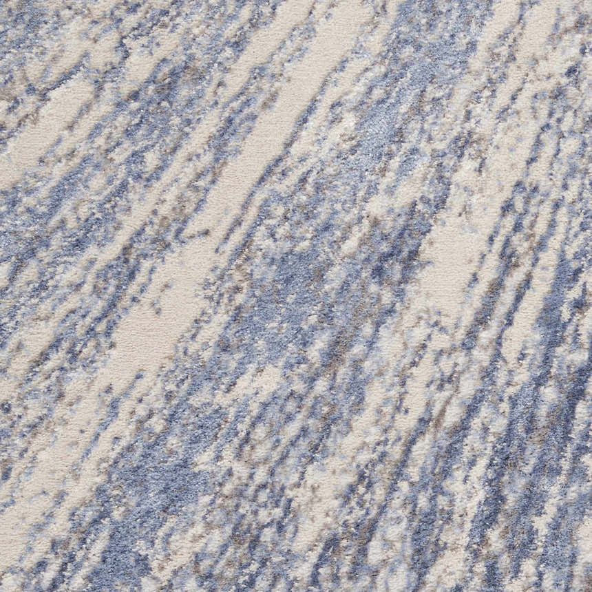 Close-up of the Nourison Silky Textures Blue Grey rug. Abstract pattern with blue, gray, and ivory tones. Soft texture.