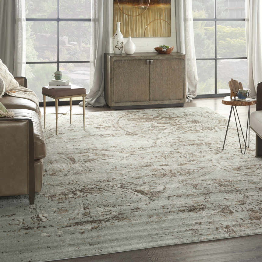 Living room scene with a grey vintage Nourison Euphoria rug, leather sofa, wood cabinet, and large windows.