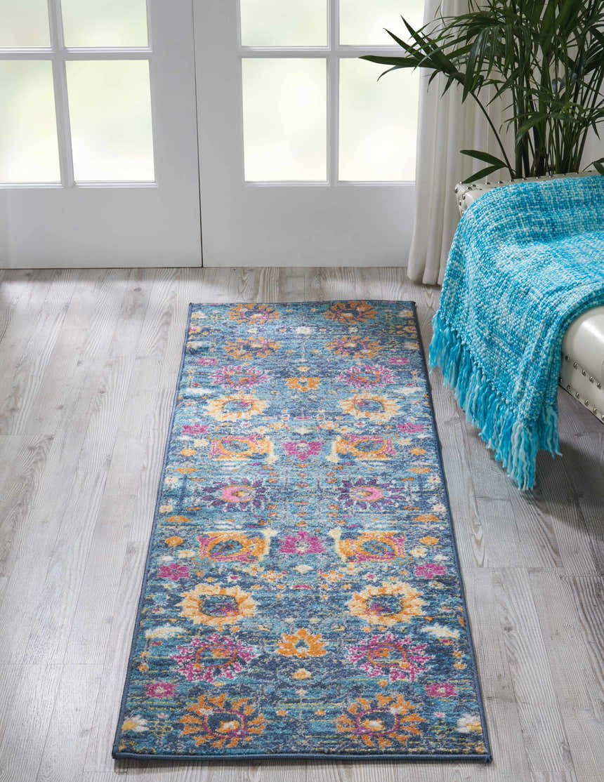 Entryway with Nourison Passion Denim Bohemian rug, floral pattern, blue, pink, and orange tones. White door and light wood floors.