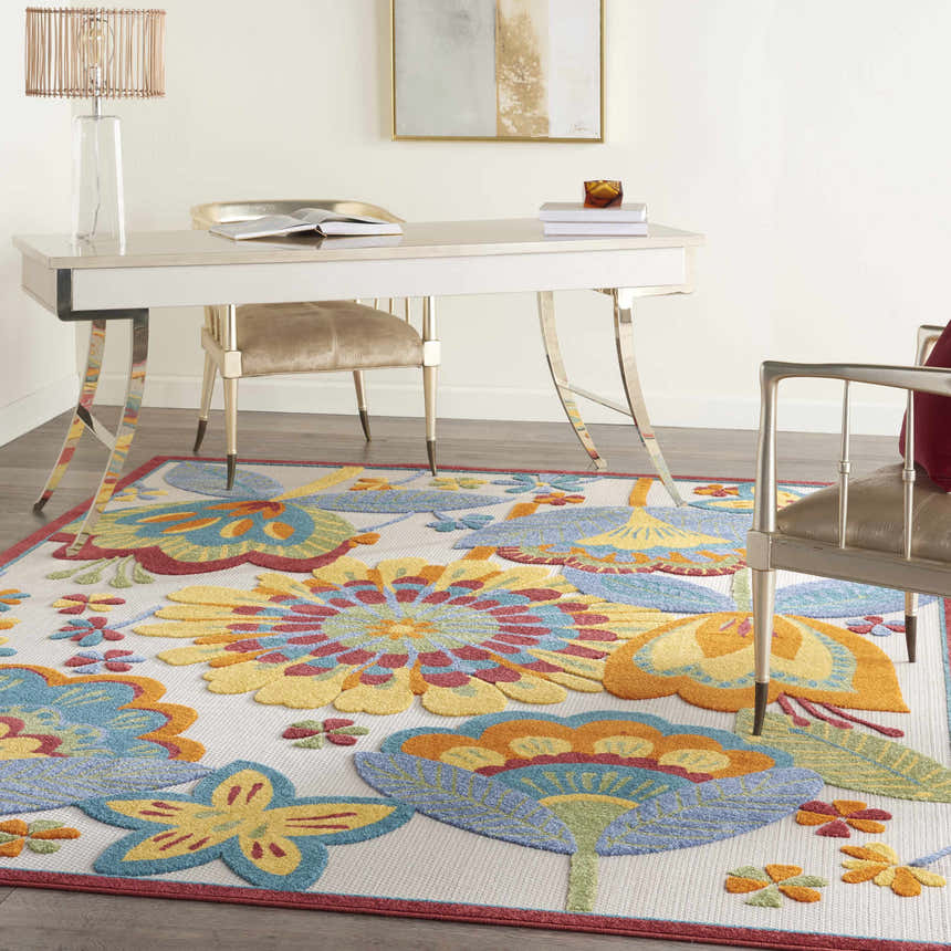 Bright office space with a Nourison Aloha Multicolor rug featuring large floral designs in yellow, blue, and orange.